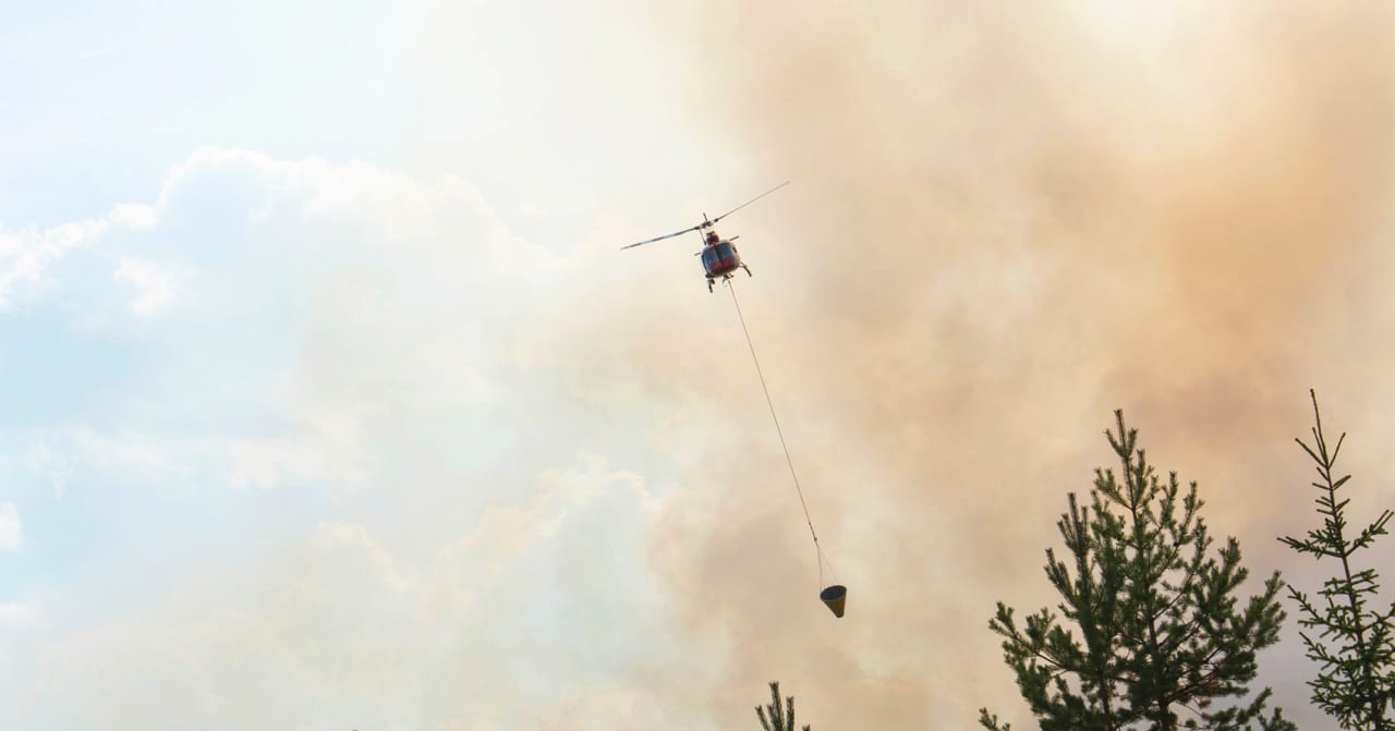 Helikopter släcker skogsbrand